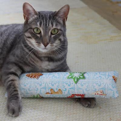 Katzenspielzeug X-Mas Kollektion Spielrolle mit graumelierter Katze auf Teppich liegend