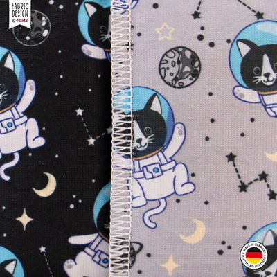 Zwei Katzen-Schmusekissen aus der 4cats Space-Kollektion, in schwarz und hellgrau, mit Motiven von Astronauten-Katzen, Nahaufnahme