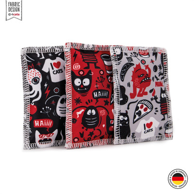 Drei Katzen-Schmusekissen aus der Crazy-Comic-Kollektion, schwarz, rot und hellgrau mit verschiedenen weißen, schwarzen und roten Motiven, stehend