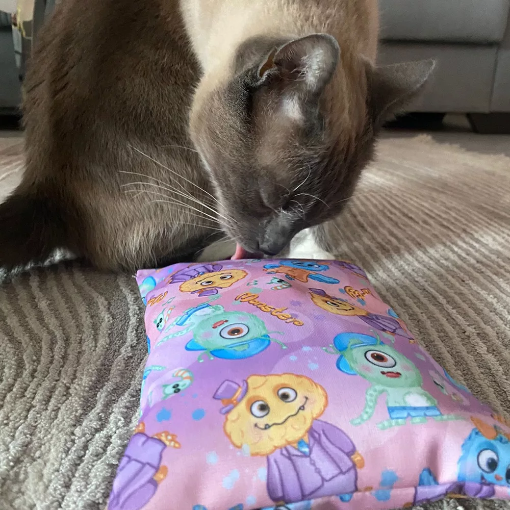 Katze leckt an Raschelkissen aus der 4cats Monster-Kollektion